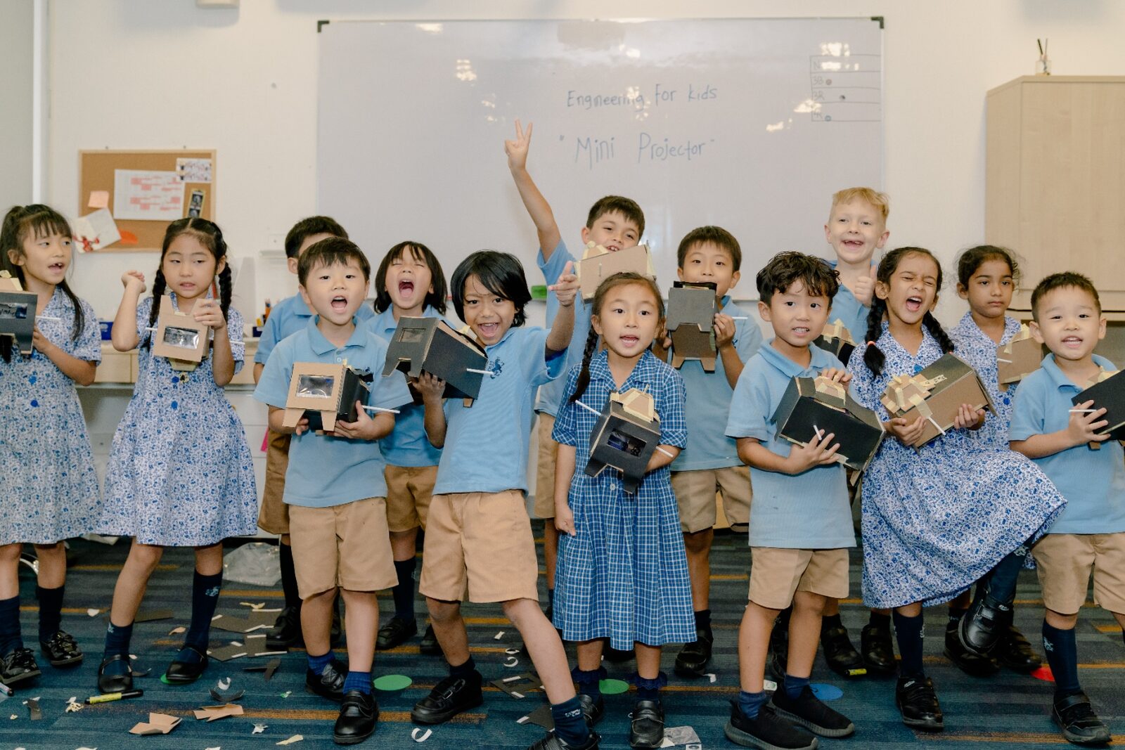 Prep School pupils proudly holding their mini projectors after an engineering project