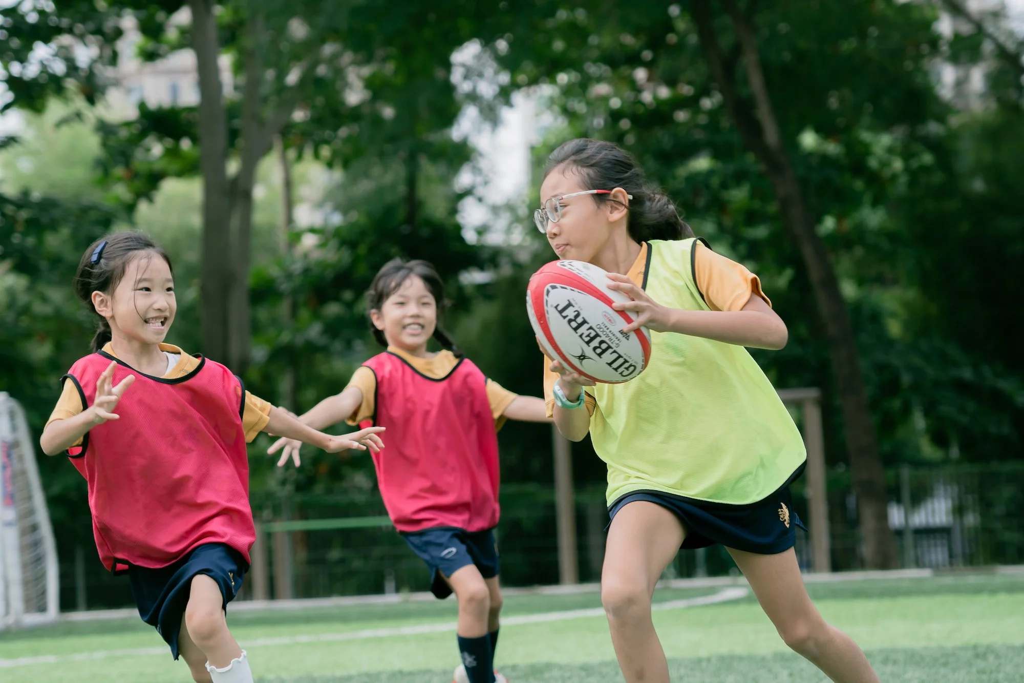 ISJ girls playing rugby on the school pitch